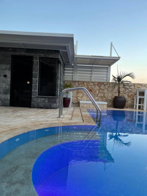 a swimming pool in front of a house at Nofesh Ba Alon 10 in Rosh Pinna