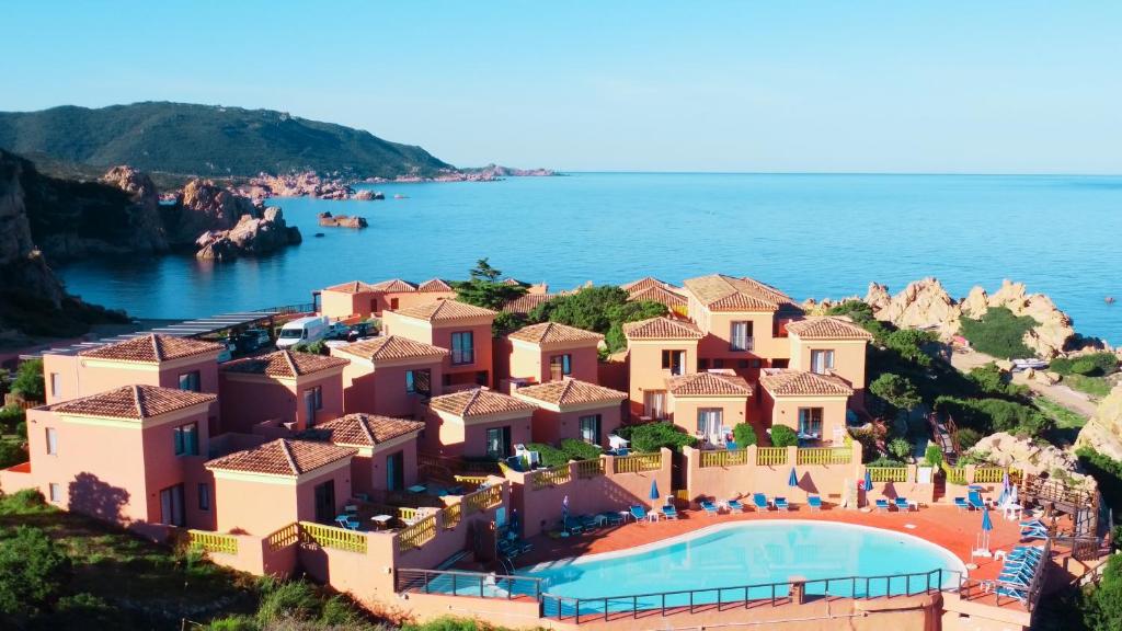 Blick auf ein Resort mit Pool und Meer in der Unterkunft Hotel Costa Paradiso in Costa Paradiso