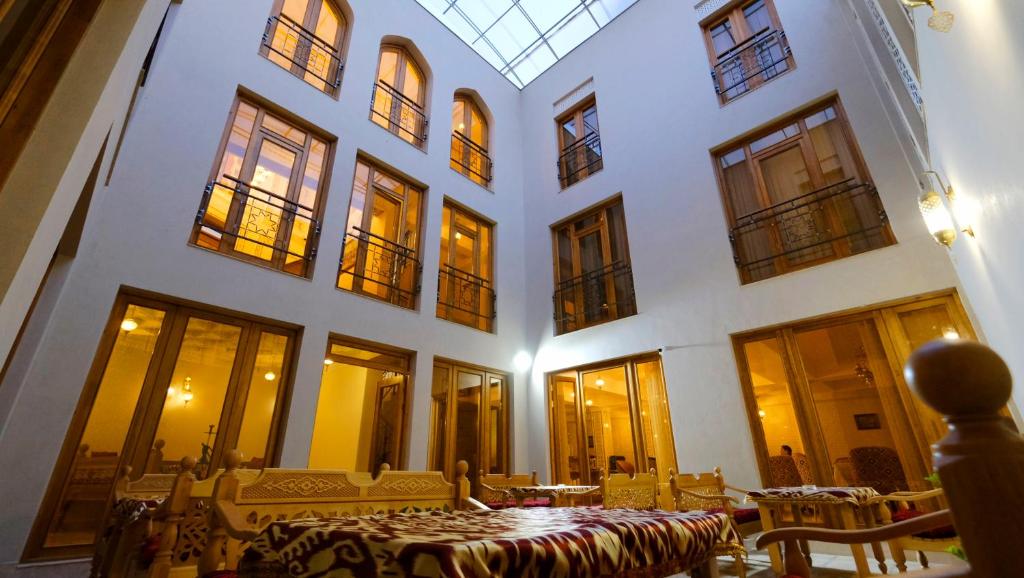 Zimmer mit einem Tisch in einem Gebäude mit Fenstern in der Unterkunft Hotel Shaherezade Garden in Buxoro