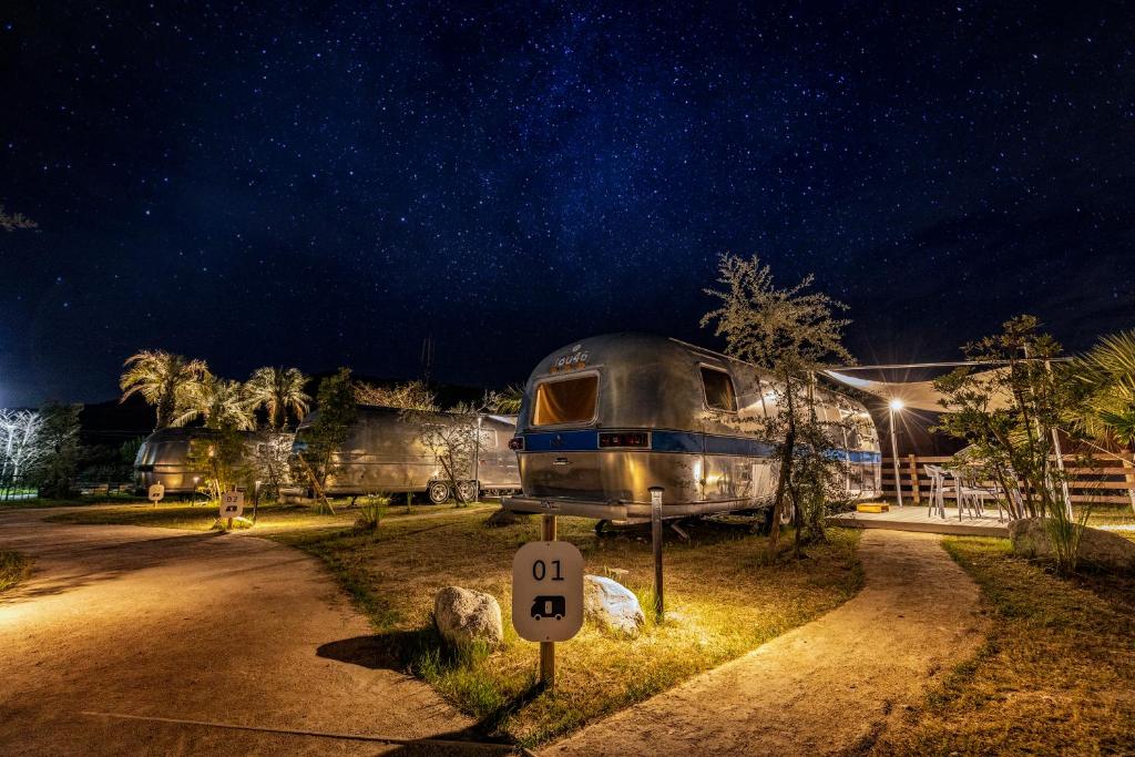 a camper parked in front of a house at night at THE Retreat in Iizuka