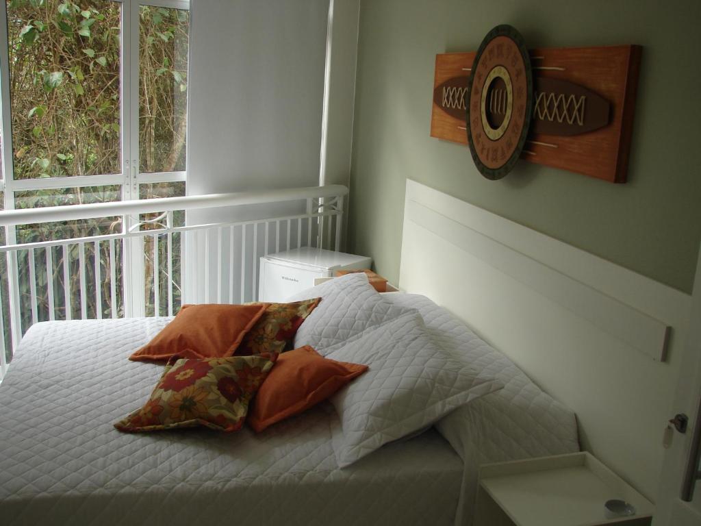 a bedroom with a bed with pillows and a window at Pousada Lava-Pés in Itambé do Mato Dentro