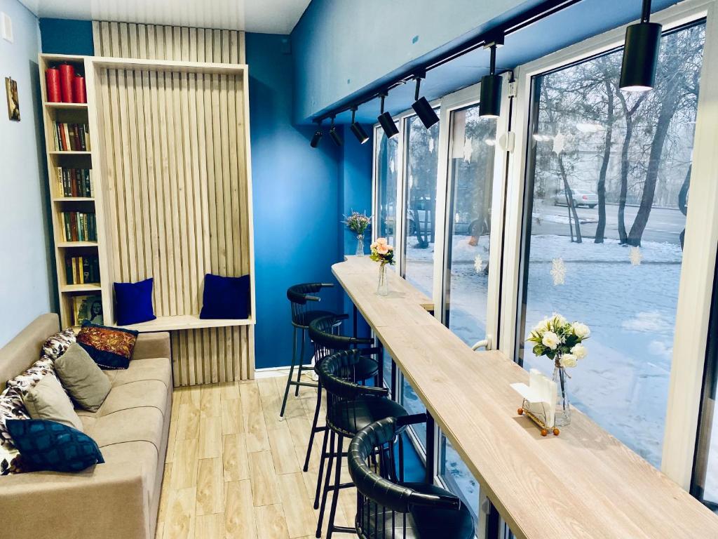 a bar in a room with blue walls and a couch at Like Home Hostel na Shevchenko, 162Б in Almaty