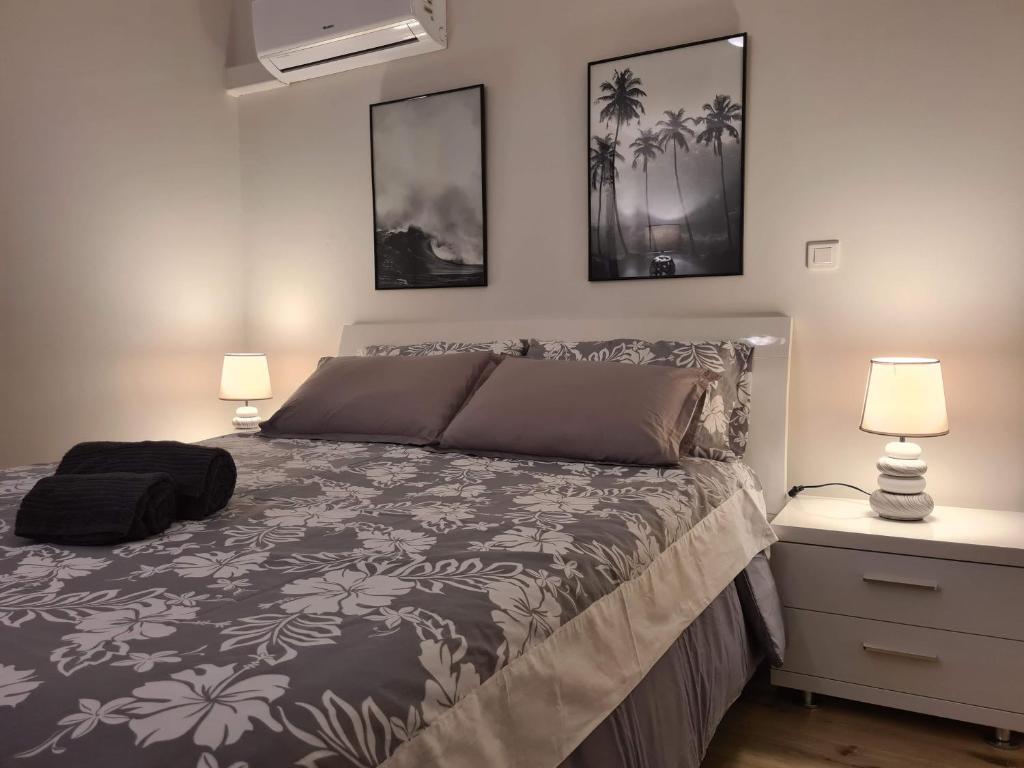 een slaapkamer met een bed met twee lampen erop bij Studio Ninirei in Papeete