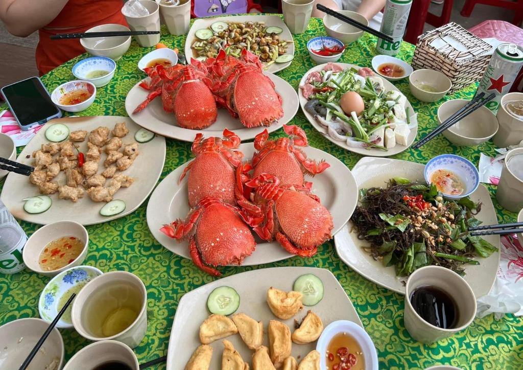 una mesa llena de comida con langostas y otros alimentos en Khách Sạn Thiên Trí Lý Sơn, en Ly Son
