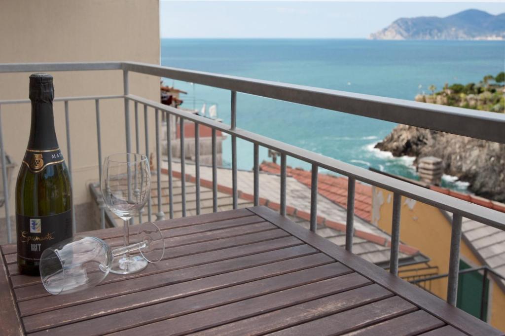 a bottle of wine and a wine glass on a balcony at Casa Vacanze Da Paulin in Manarola