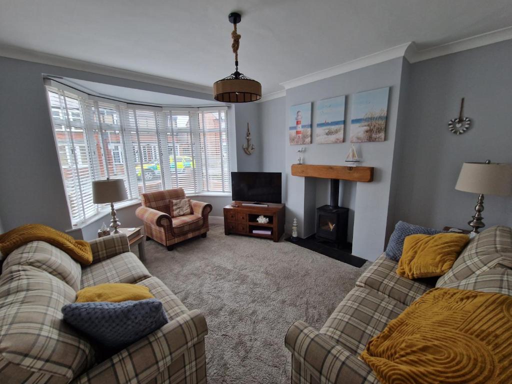 a living room with two couches and a television at Wishbone House in Bridlington