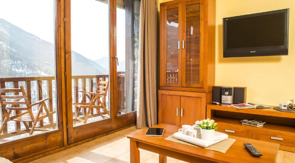 a living room with a television and a balcony at Appartement Ona Dorada el Tarter in Ransol