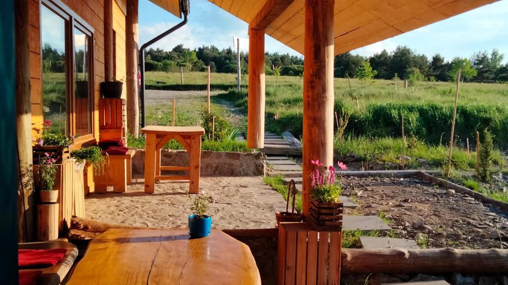 eine Veranda eines Hauses mit einem Holztisch in der Unterkunft Osada Kabardia in Nowica