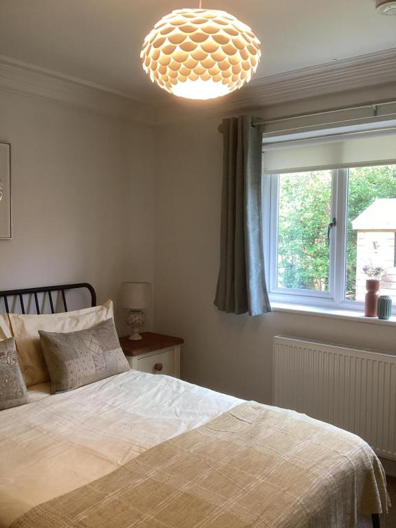 a bedroom with a bed and a chandelier at Forest Heath Holidays - Denphyl in Ringwood