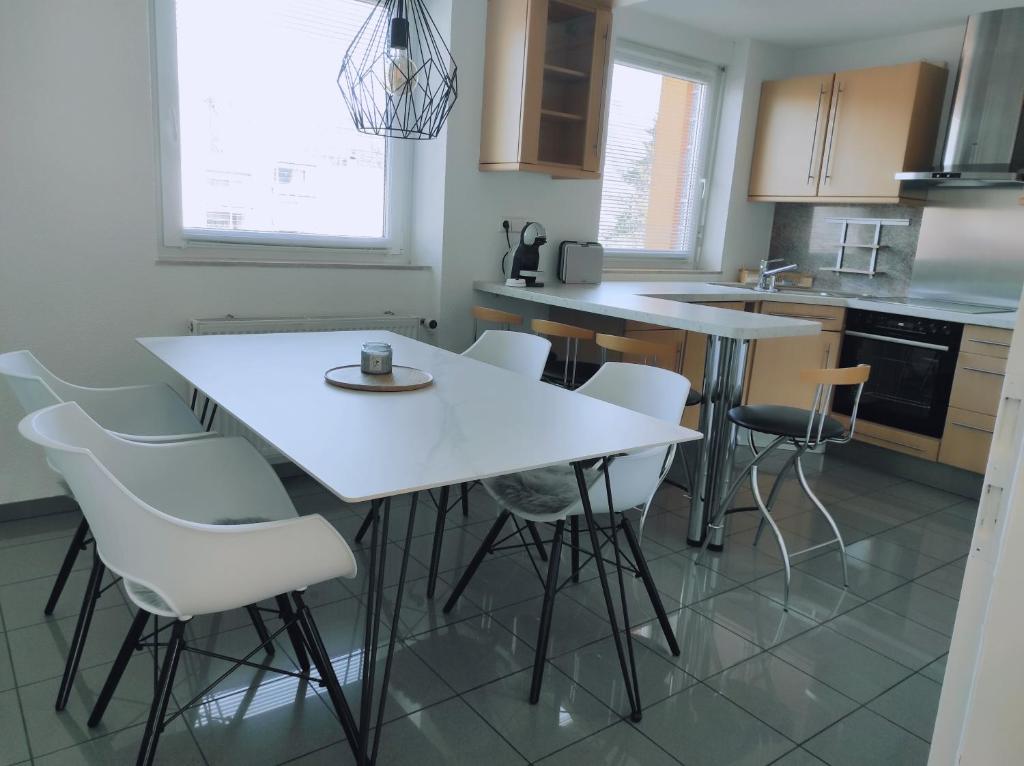 una cucina con tavolo bianco e sedie bianche di Apartment Waldblick - 77 qm, 2 Schlafzimmer, Balkon und Wi-Fi a Maulburg
