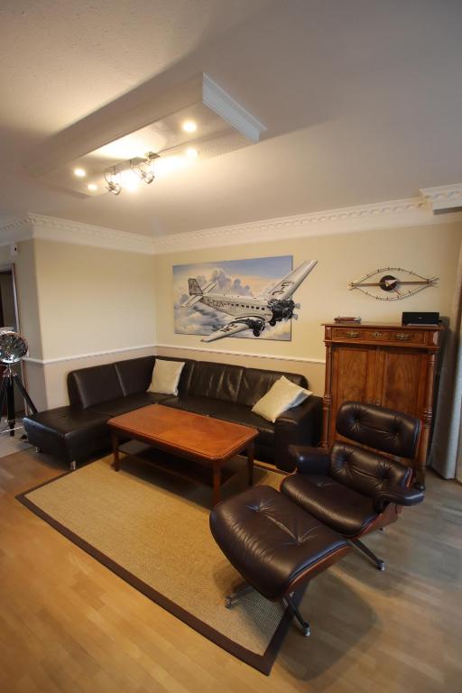 a living room with a couch and a table and chairs at Großzügiges Appartement nähe Hannover-Messe in Hannover