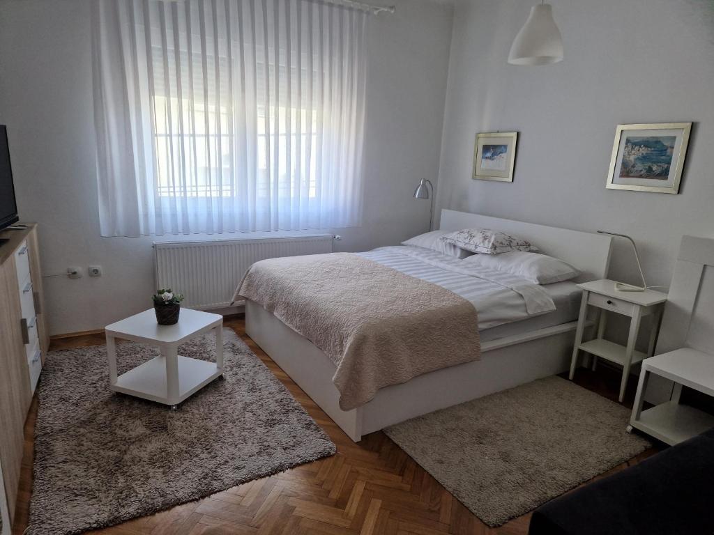 a white bedroom with a bed and a window at "Apartment Lavanda Idila", speed WiFi in Zagreb
