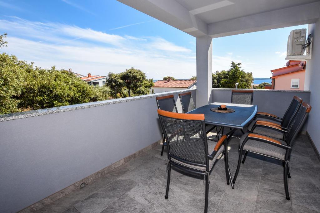 een patio met 2 stoelen en een tafel op een balkon bij Lavanda in Mandre
