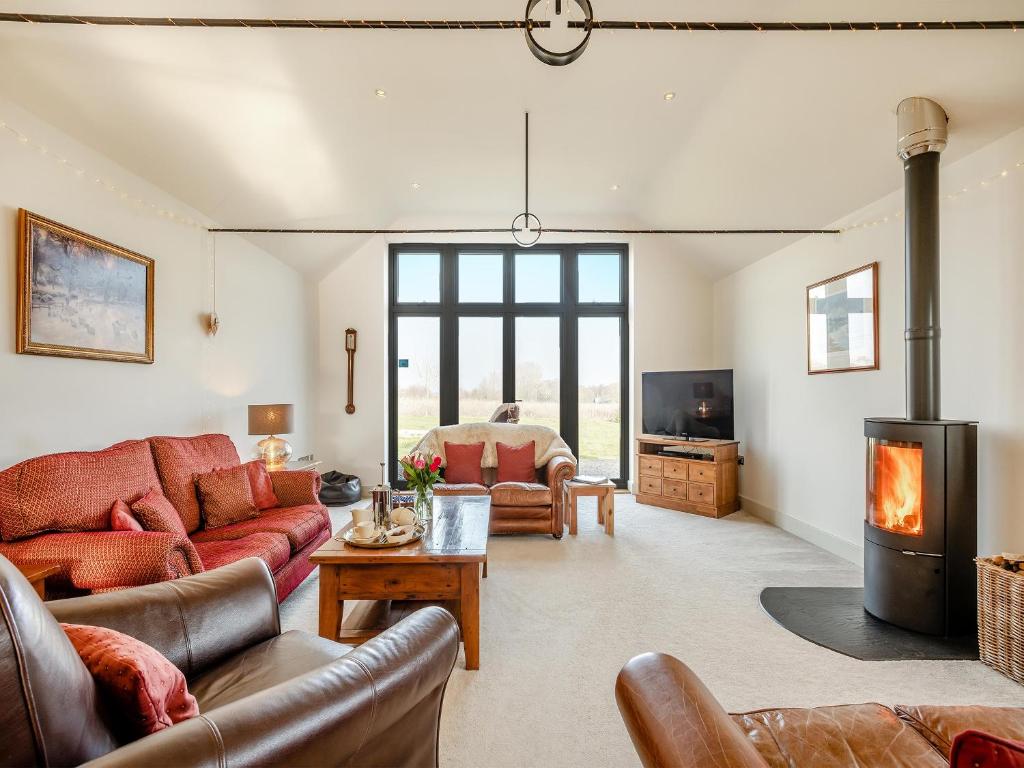 a living room with a couch and a fireplace at Archies Barn in Lenwade