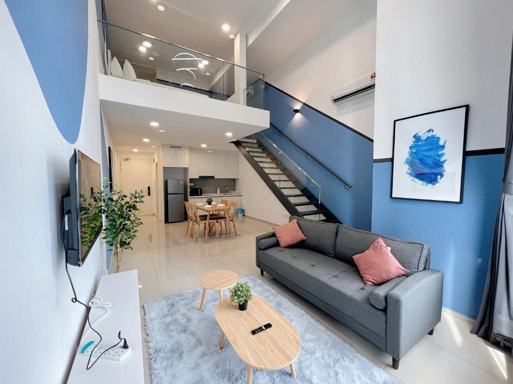Una sala de estar con un sofá y una escalera. en EkoCheras Suite by MOKA, en Kuala Lumpur