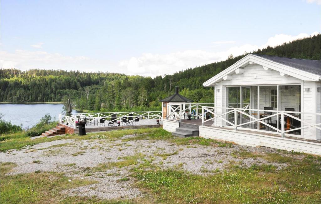 ein weißes Haus mit einer Veranda am See in der Unterkunft Lovely Home In Kil With Wifi in Kil