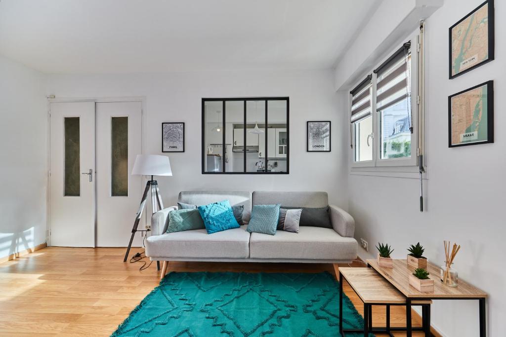 - un salon avec un canapé et un tapis bleu dans l'établissement Le Kennedy, à Trouville-sur-Mer