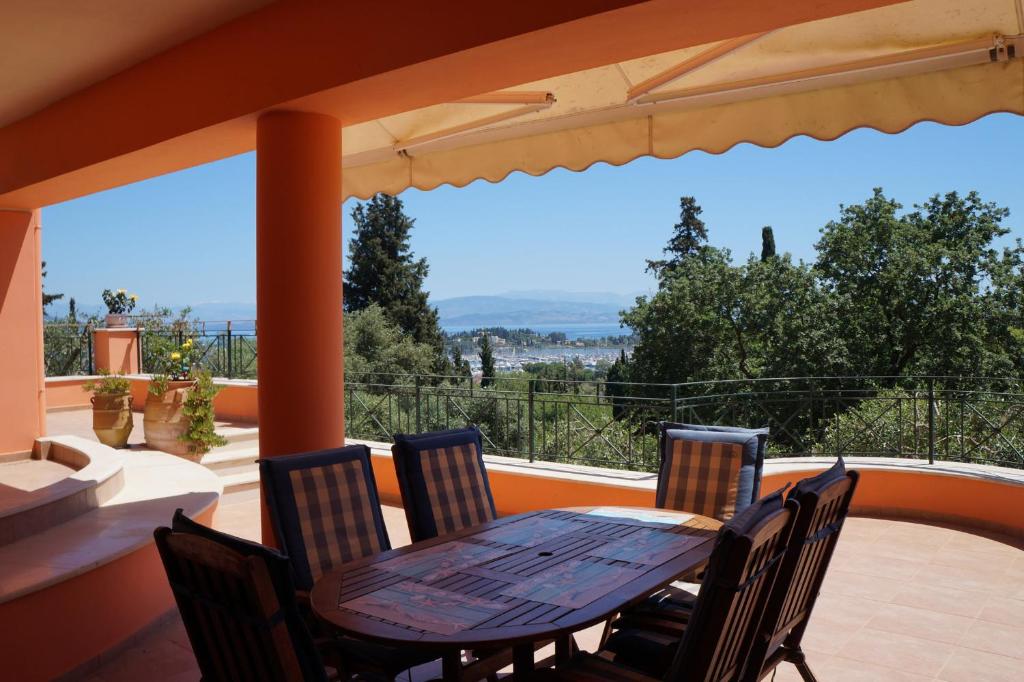 a wooden table and chairs on a patio with a view at StarLight SeaView in Gouvia