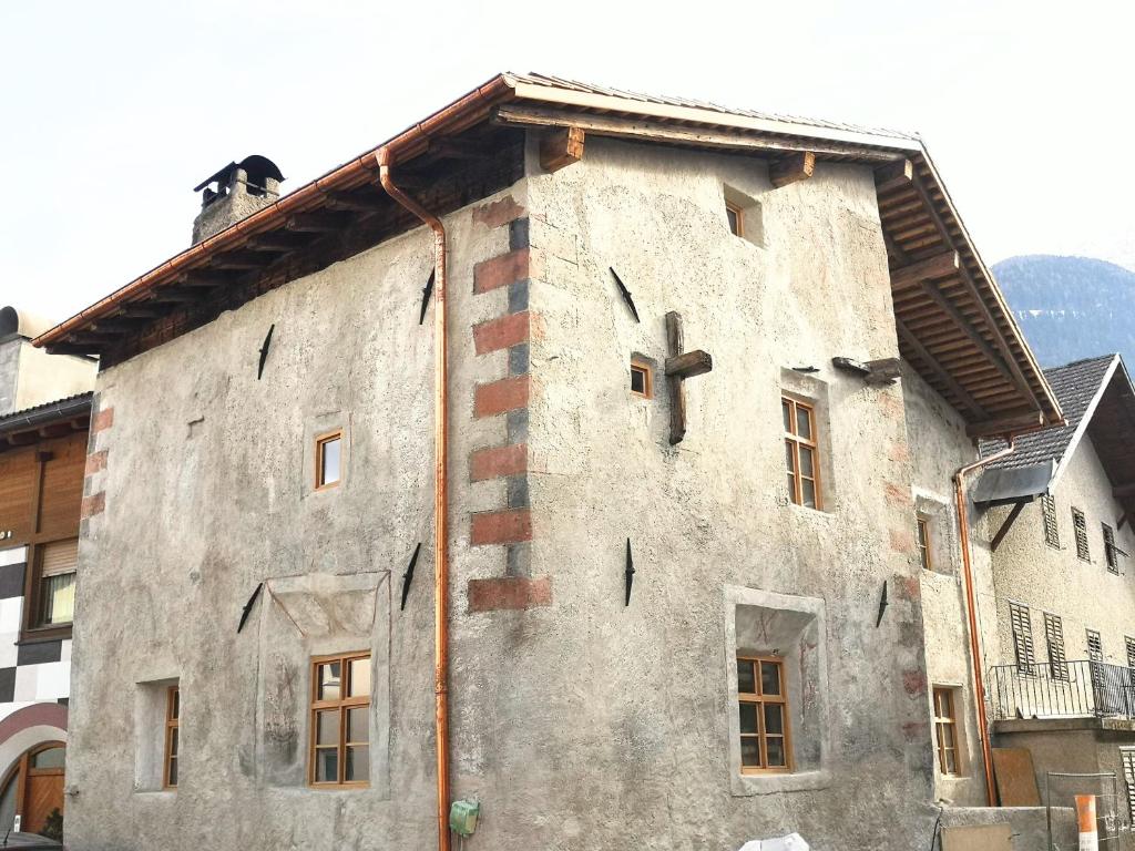 a building with a cross on the side of it at Historisches Townhouse in Prad in Prato allo Stelvio