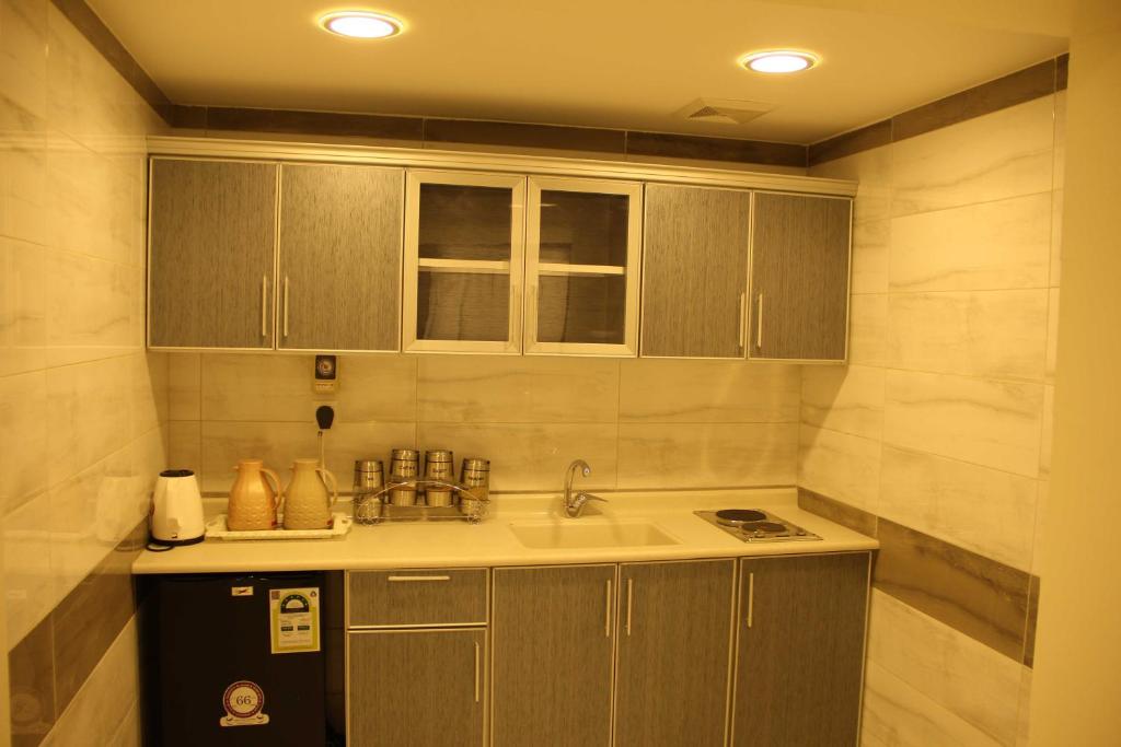 a small kitchen with a sink and a refrigerator at الجناح الأبيض للأجنحه الفندقية in Dammam