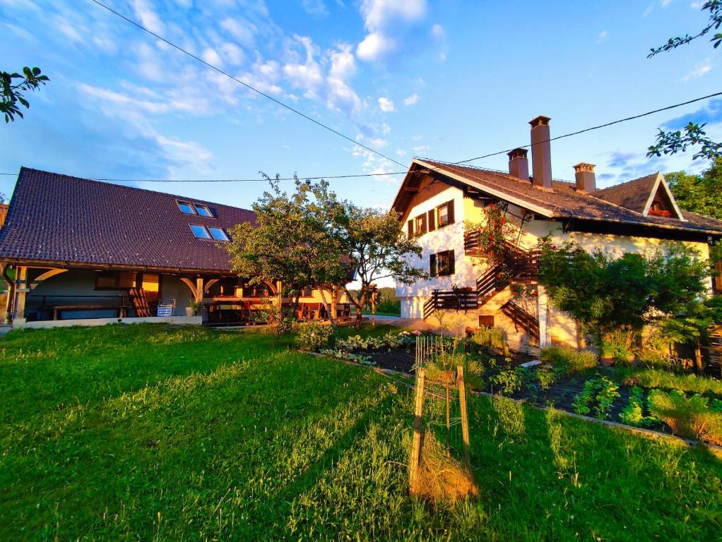 a large house with a green lawn in front of it at Tourist Farm Strle With Great Local Food in Cerknica