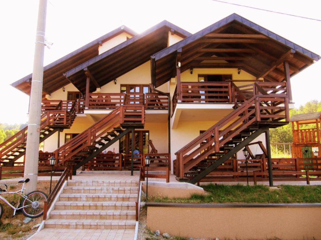 ein Gebäude mit Holztreppe und einem Fahrrad vor dem Haus in der Unterkunft Gočke Lux vile & Duplex in Vrnjačka Banja