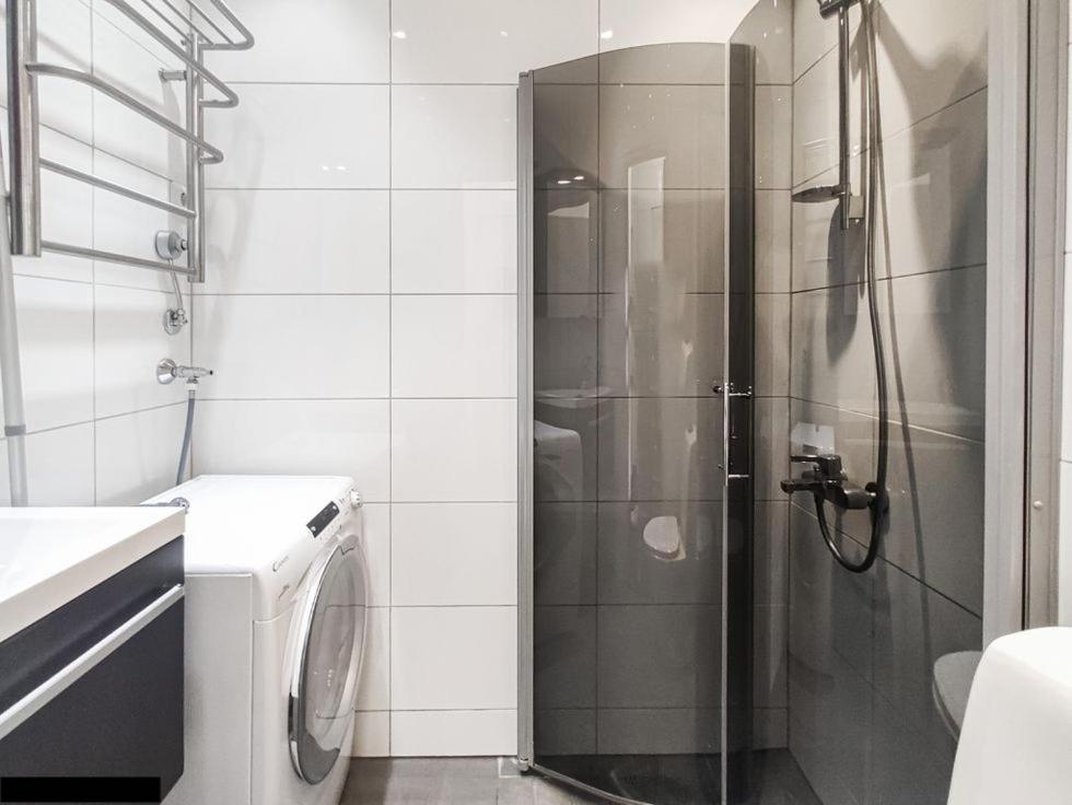 a bathroom with a shower and a washing machine at Central Boutique in Helsinki