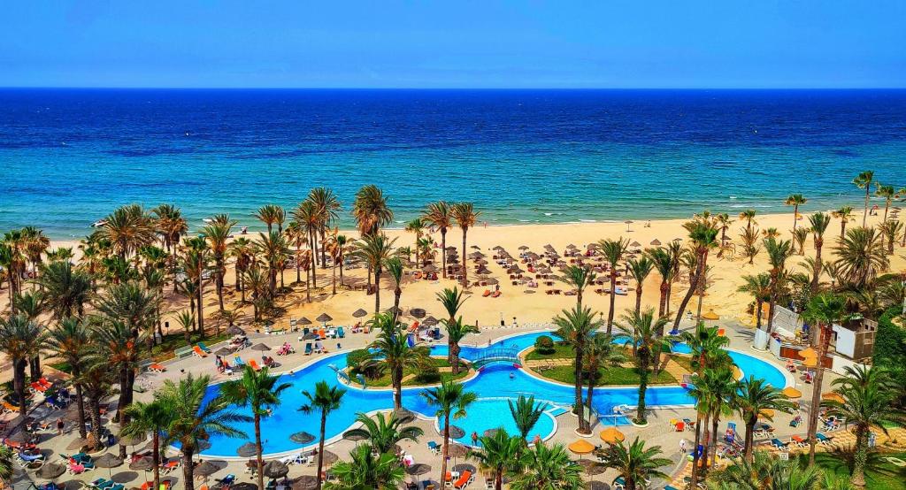 eine Luftansicht auf einen Strand mit Menschen und das Meer in der Unterkunft Riadh Palms- Resort & Spa in Sousse