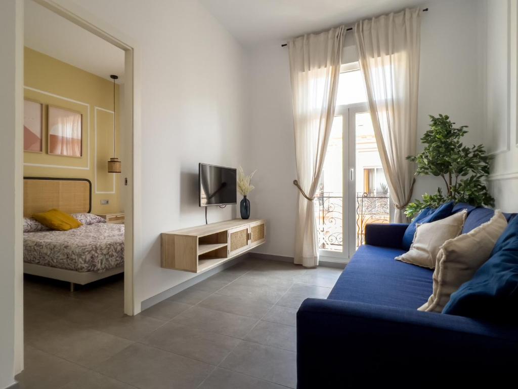 a living room with a blue couch and a television at Maritime Apartamentos Valencia in Valencia