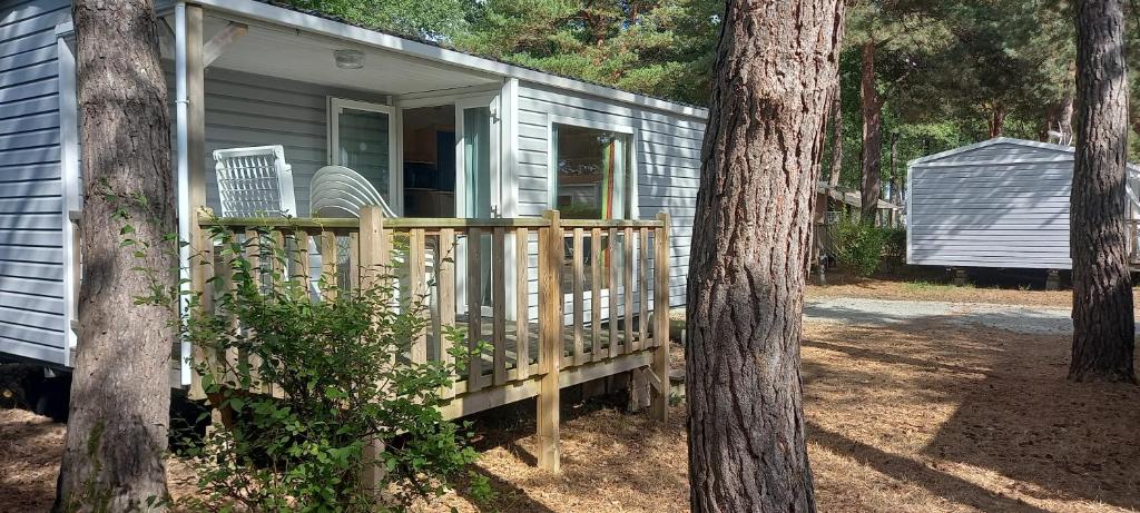 un porche de una casa con dos sillas en Camping Cœur De Vendée, en La Boissière-de-Montaigu