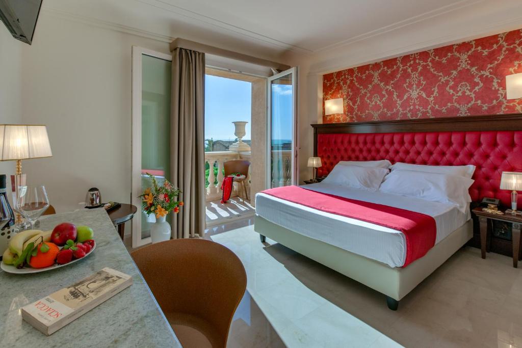 um quarto com uma cama e uma mesa com uma tigela de fruta em La Paloma Blanca Hotel em Sciacca