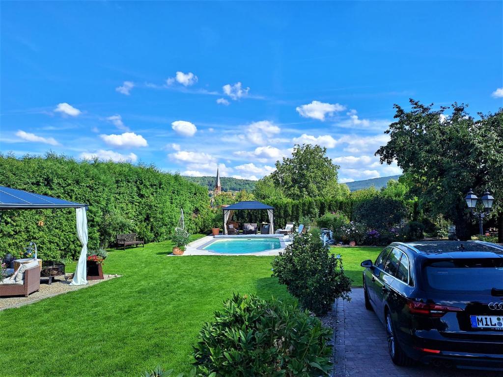 a car parked in front of a yard with a swimming pool at Apartamento Albertina in Kleinheubach