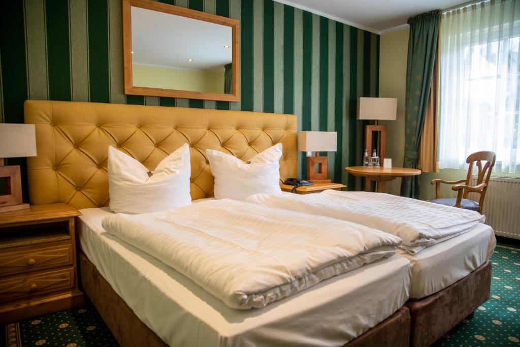 a bedroom with a large bed with a large headboard at Hotel Fliegerheim in Borkheide