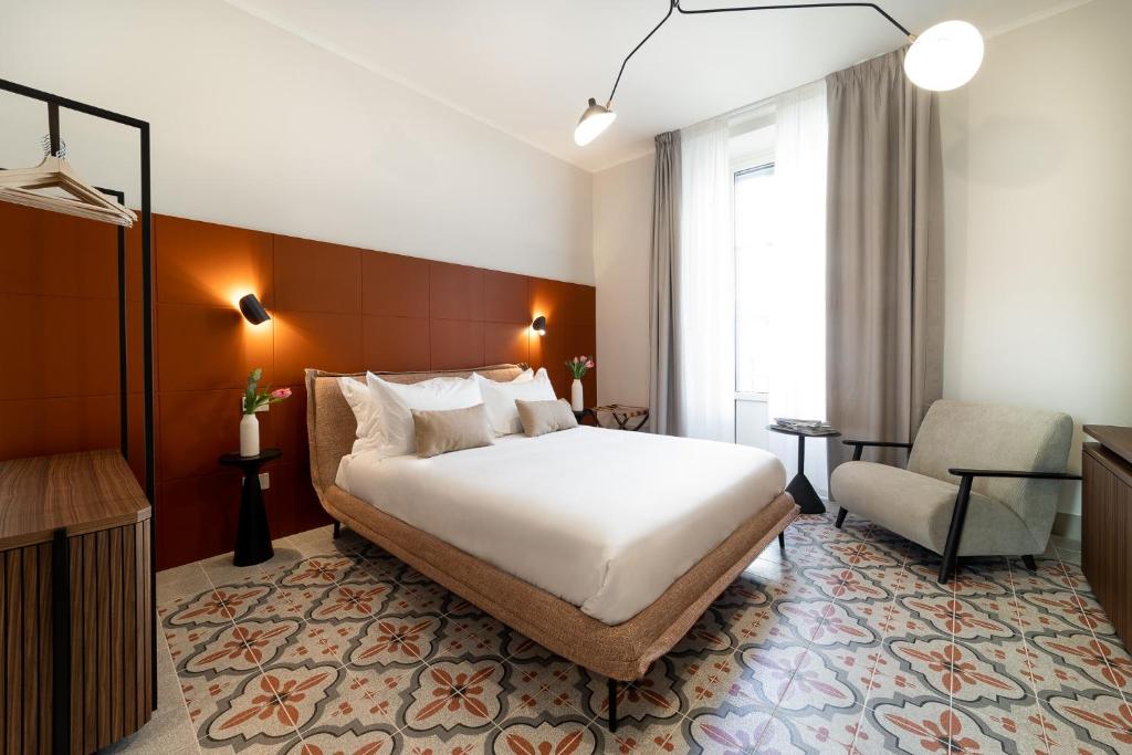 a bedroom with a large white bed and a chair at Cà Bèla - Pergolesi in Milan