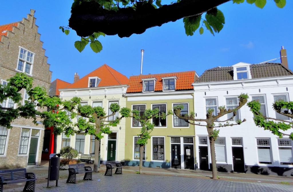 un grupo de edificios con árboles delante de ellos en B&B Vierwinden, en Vlissingen