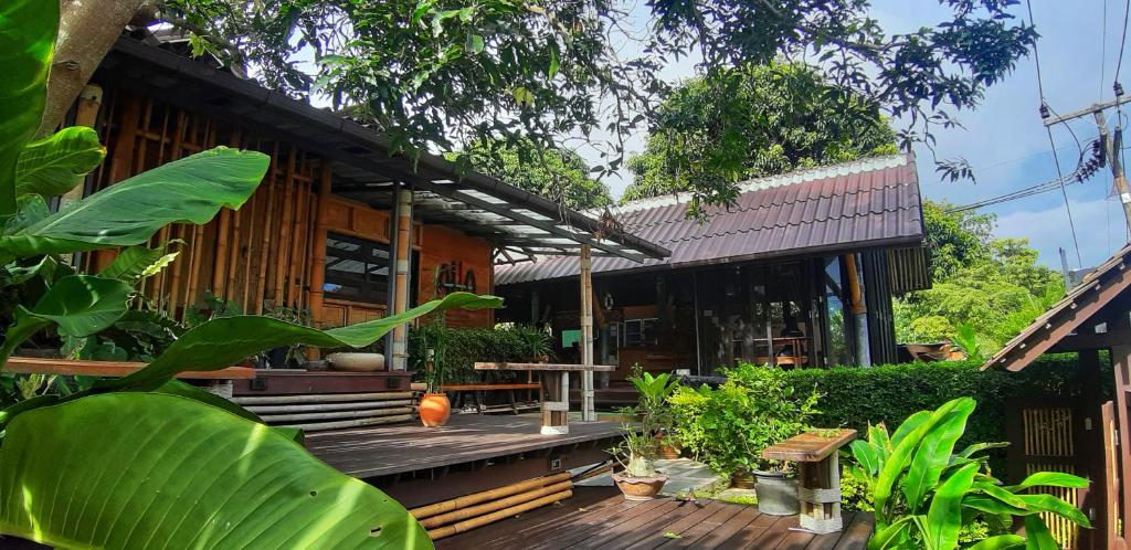 a house with a wooden deck in front of it at Aha Lanta Cozy Hostel in Ko Lanta