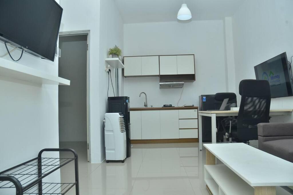 a room with a kitchen and a living room at Homey Homestay at Citraland Cirebon in Cirebon