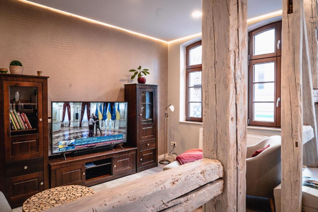 a living room with a television in a wooden cabinet at Apartment am Markt in Aschersleben