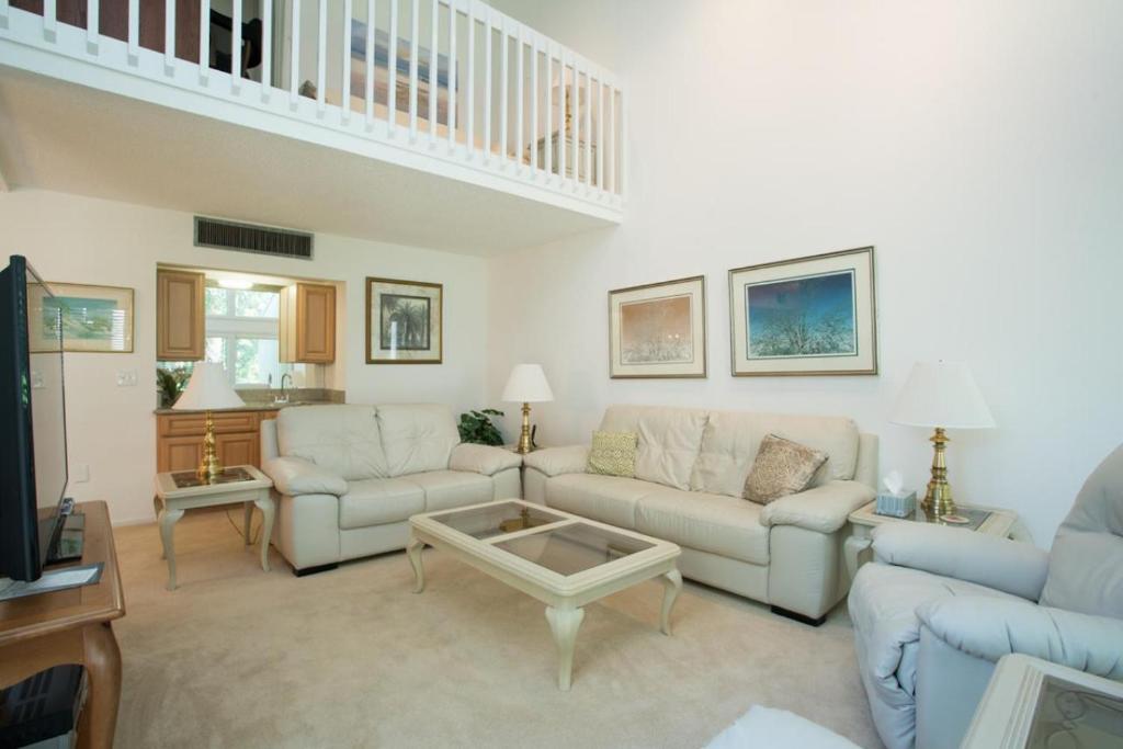 a living room with two couches and a table at Shady Palms in Ponte Vedra Beach