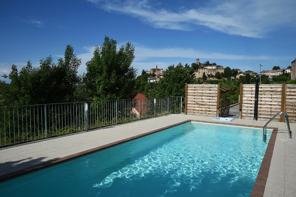 uma grande piscina com um deque de madeira em Hotel Villa Lauri em Neive