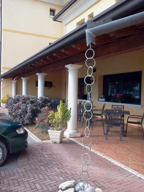 a chain hanging from a building with a patio at Albergo Al Portico in Azzano Decimo