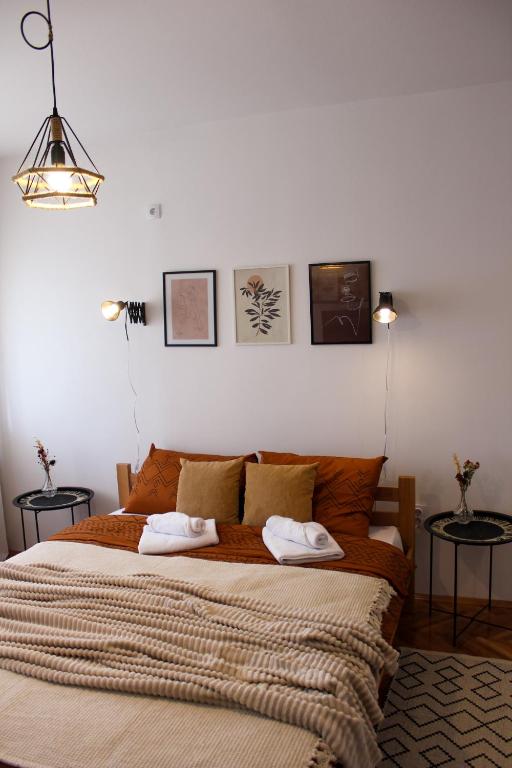 a bedroom with a large bed with two towels on it at Bohome studio sa terasom - FREE PARKING in Vranje