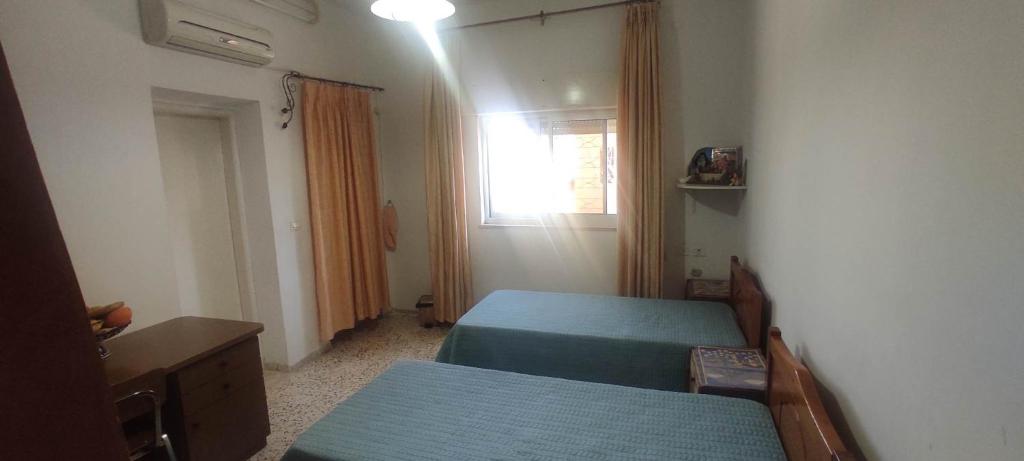 um pequeno quarto com 2 camas e uma janela em Reema's House em Bayt Sāḩūr