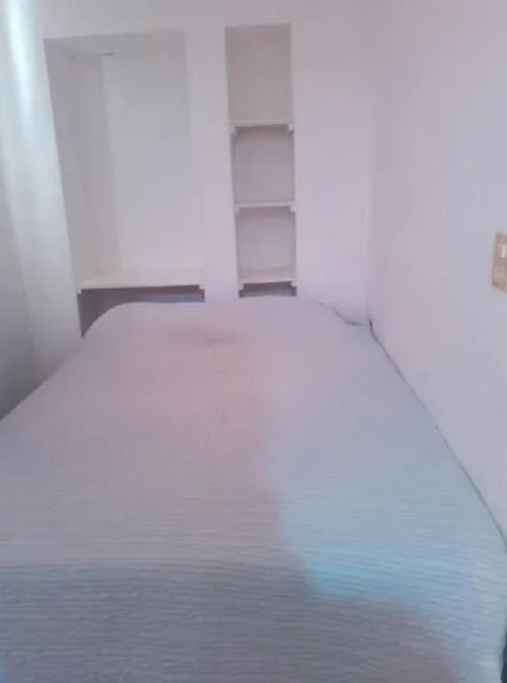 Habitación con cama blanca. en Cabaña para exploradores 600 mts del centro en El Calafate