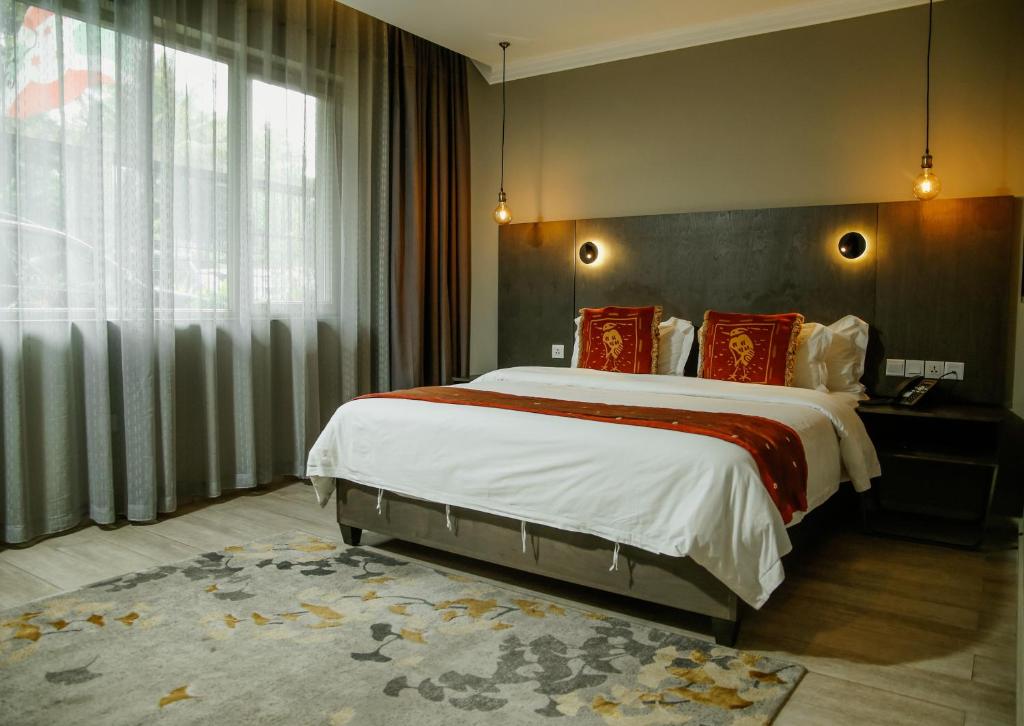 ブジュンブラにあるKiriri Garden Hotelのベッドルーム(大型ベッド1台、大きな窓付)