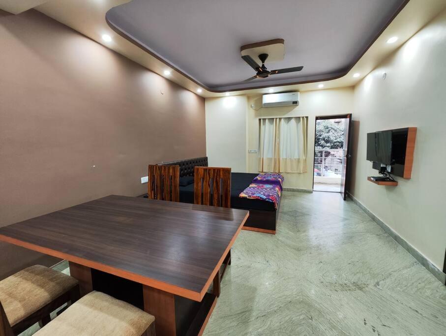 a dining room with a wooden table and chairs at Modern 3BHK Apt for Big Groups & Family in Kasba in Kolkata