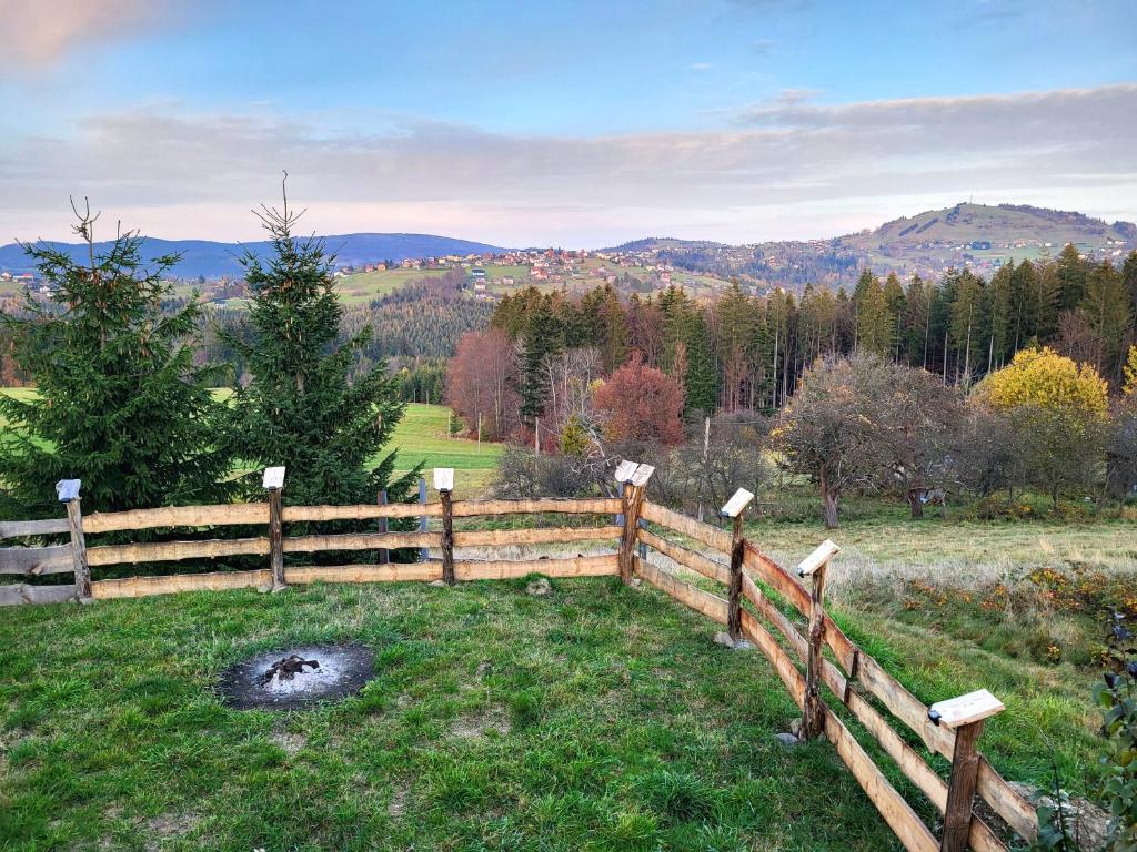 a wooden fence in a field with mountains in the background at Apartament w Chmurach in Jaworzynka
