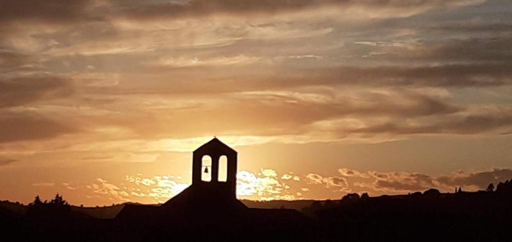 a silhouette of a church with the sunset in the background at appartement chez l'artiste in Minerve