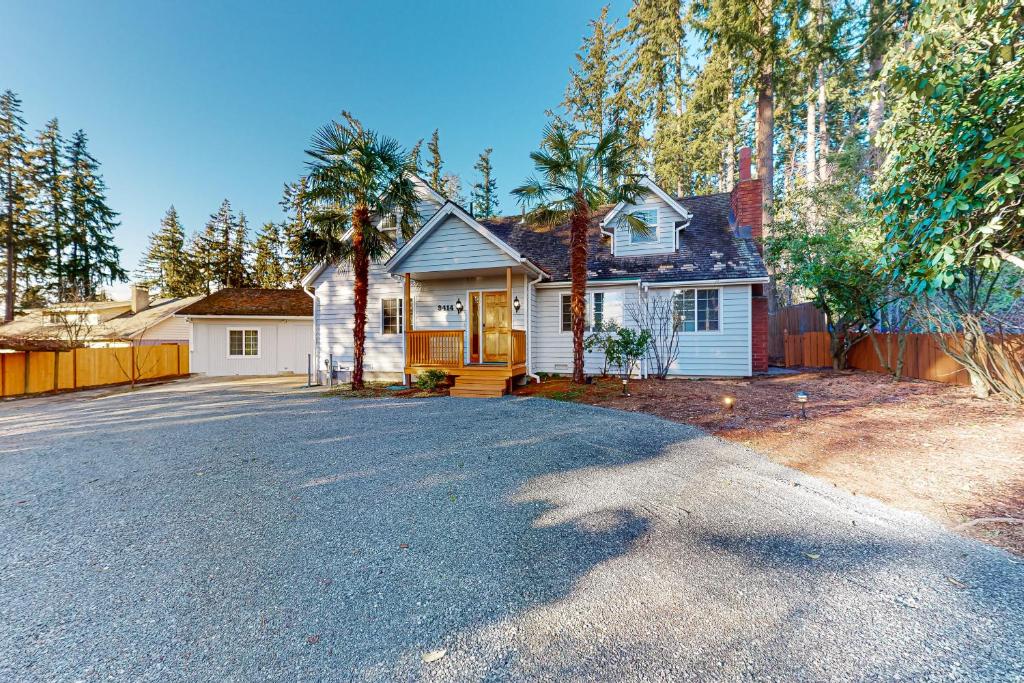 a white house with a fence and a driveway at The Little Wing Roost in Renton