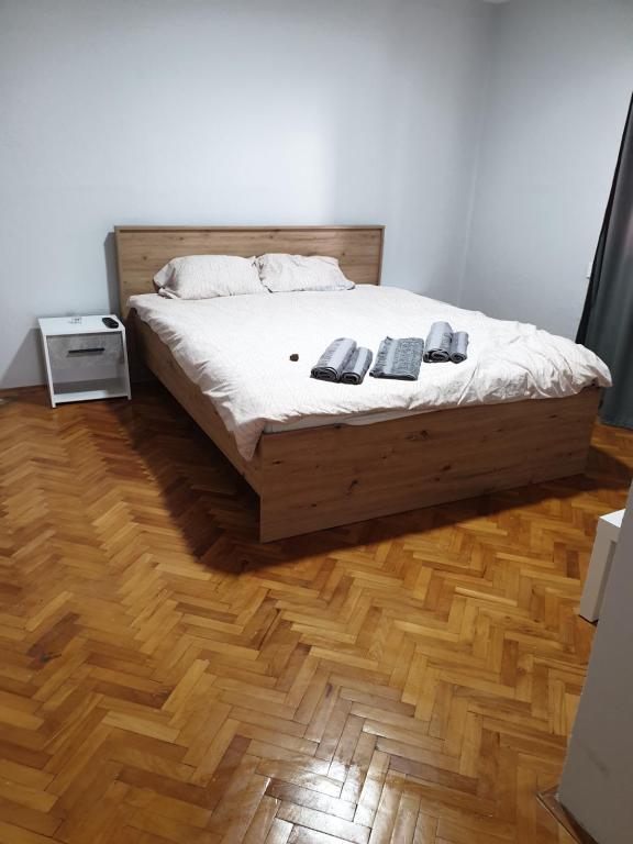 a bedroom with a bed and a wooden floor at Fenix Apartman in Zaječar